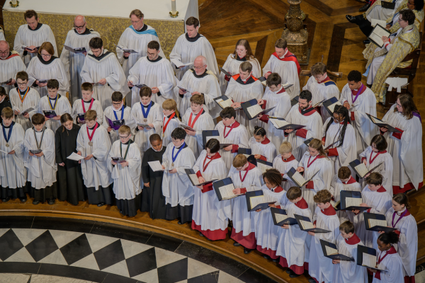 The choir of Rochester Cathedral, dressed in white and red robes.