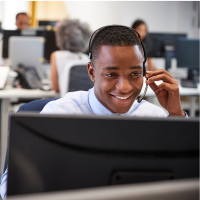 A man sitting in front of a computer in a call centre.